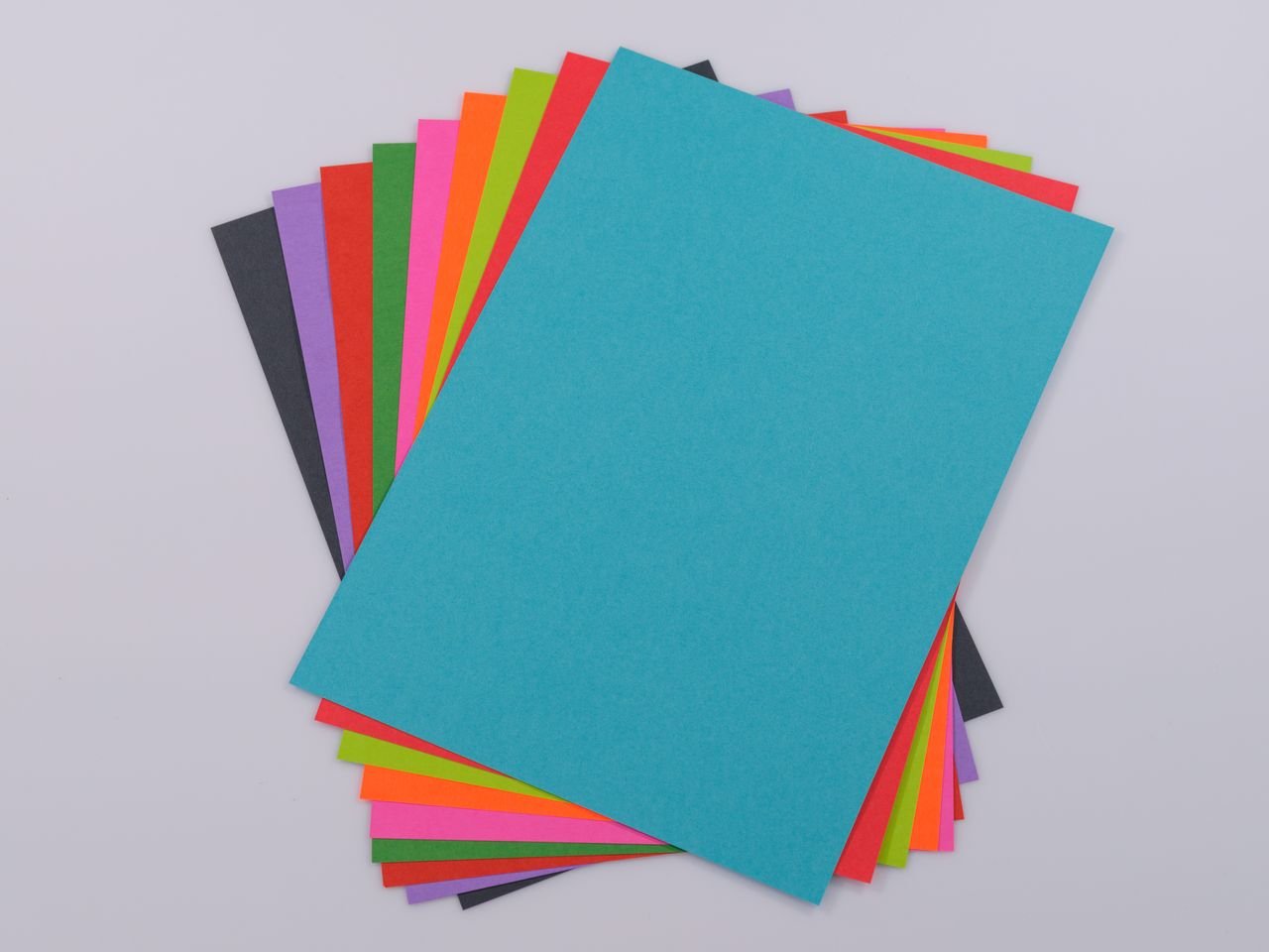 E-Shop High-quality vibrant colored paper stack on a neutral white background, perfect for creative projects.