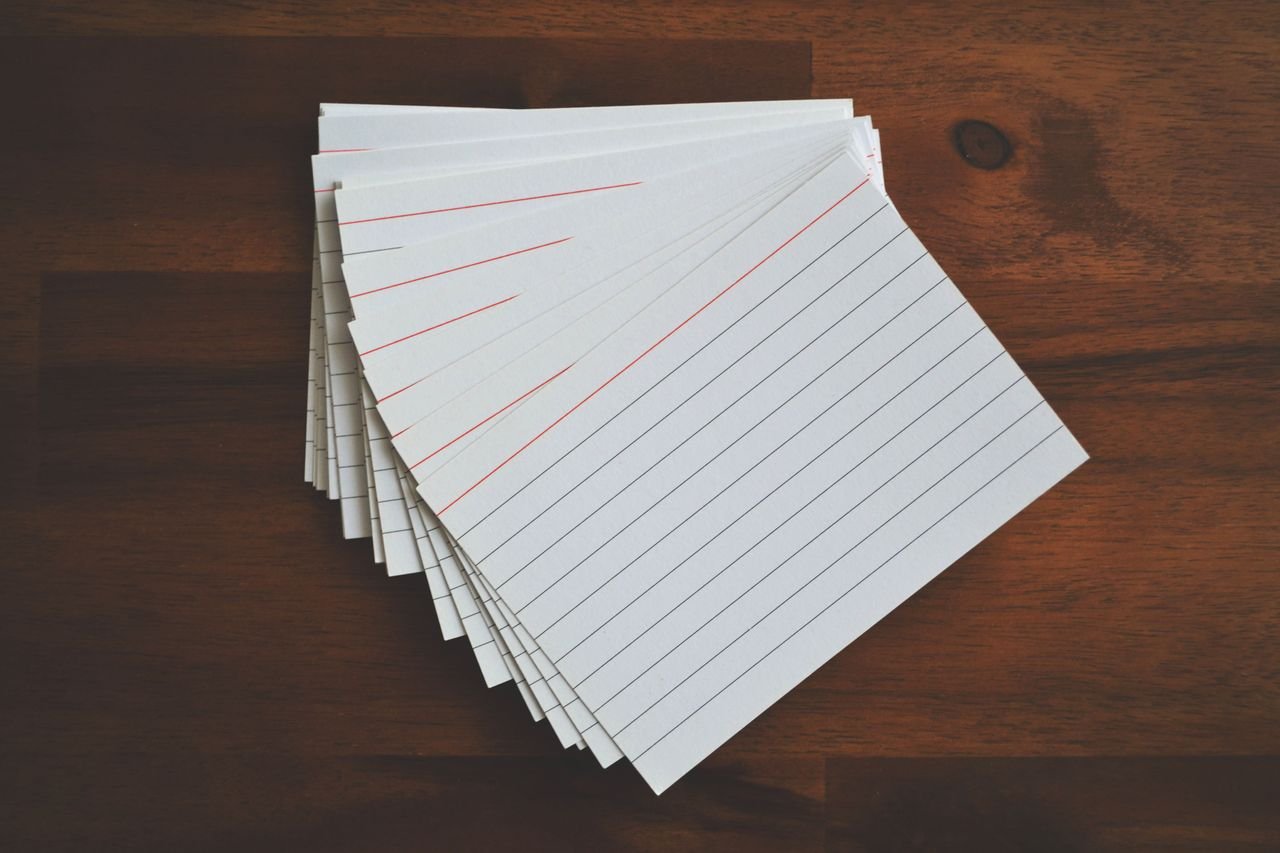 E-Shop High-angle view of blank index cards arranged neatly on a wooden desk, ideal for education and organization concepts.